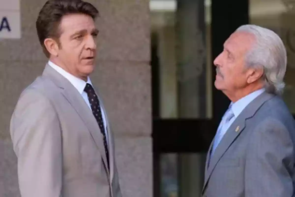 Dos hombres de traje conversan frente a un edificio. Dos hombres de traje conversan frente a un edificio.