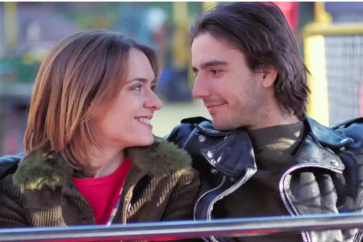 Una pareja sonriente mirándose a los ojos en un ambiente al aire libre. Una pareja sonriente mirándose a los ojos en un ambiente al aire libre.