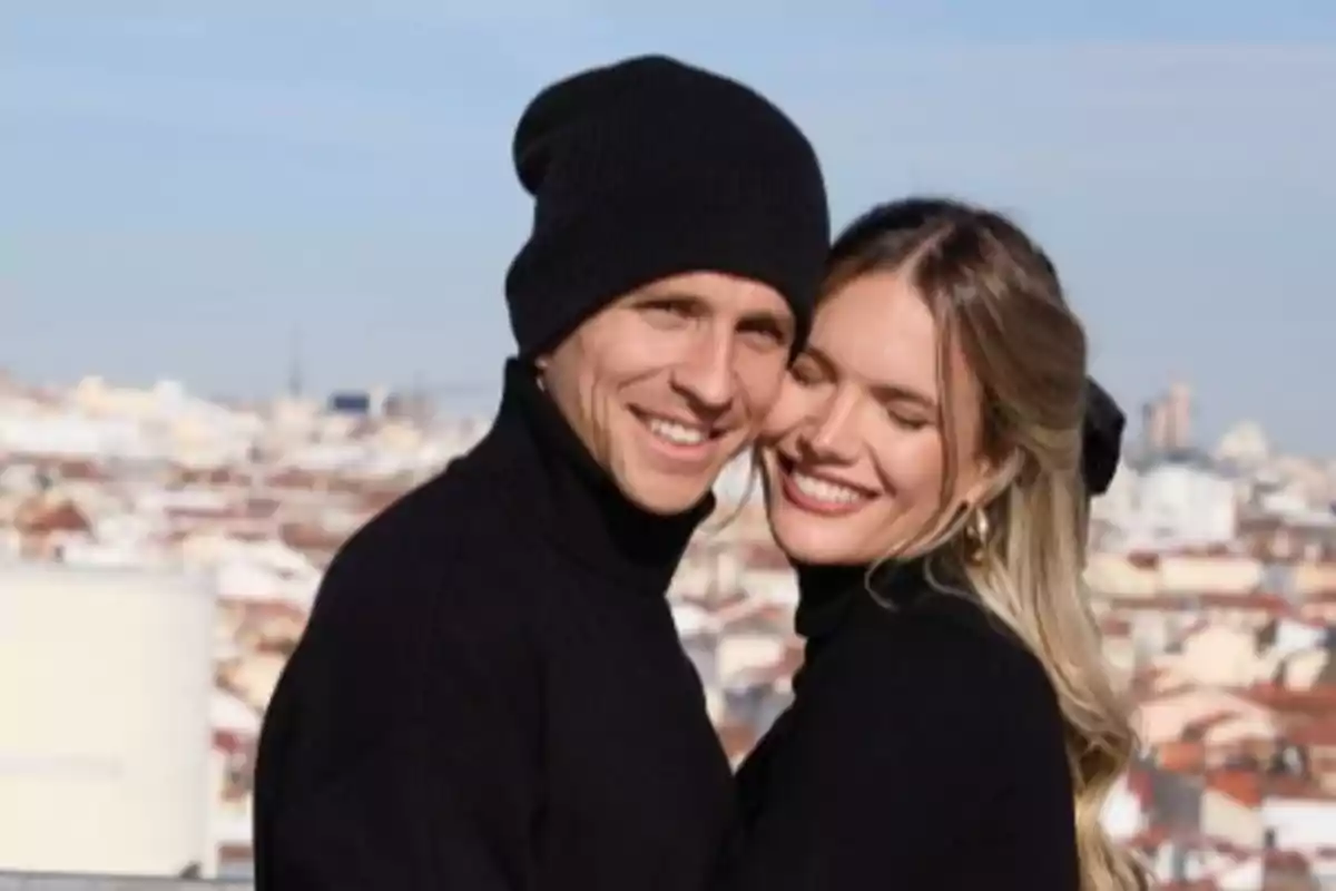 Una pareja sonriente abrazándose con un paisaje urbano de fondo. Una pareja sonriente abrazándose con un paisaje urbano de fondo.