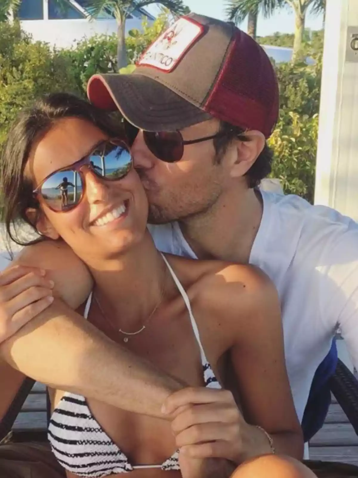 Una pareja disfrutando de un momento al aire libre, con el hombre besando a la mujer en la mejilla mientras ella sonríe. Una pareja disfrutando de un momento al aire libre, con el hombre besando a la mujer en la mejilla mientras ella sonríe.