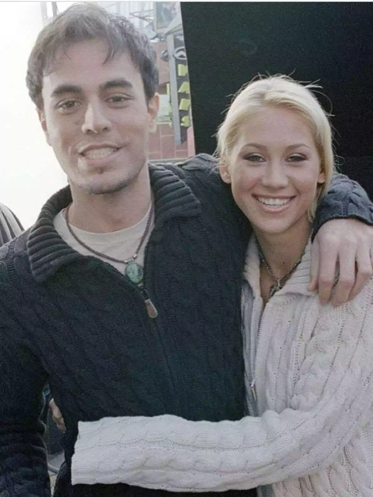 Dos personas jóvenes posan sonriendo mientras se abrazan, ambos llevan suéteres de punto. Dos personas jóvenes posan sonriendo mientras se abrazan, ambos llevan suéteres de punto.