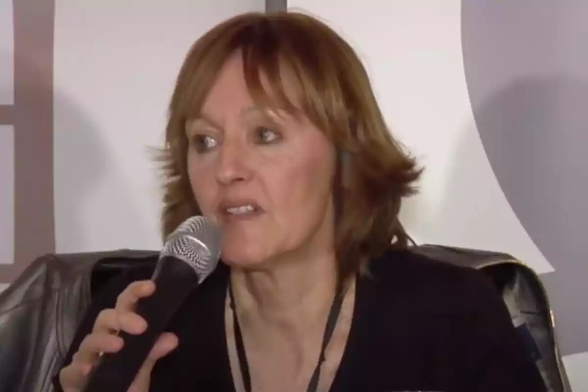 Una persona hablando en un micrófono durante un evento. Una persona hablando en un micrófono durante un evento.
