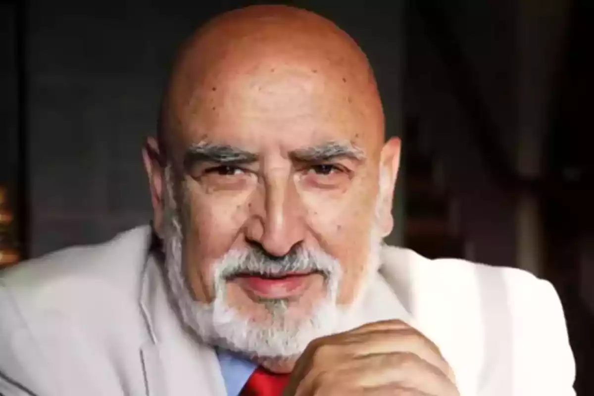 Un hombre mayor con barba blanca y traje claro mirando a la cámara. Un hombre mayor con barba blanca y traje claro mirando a la cámara.