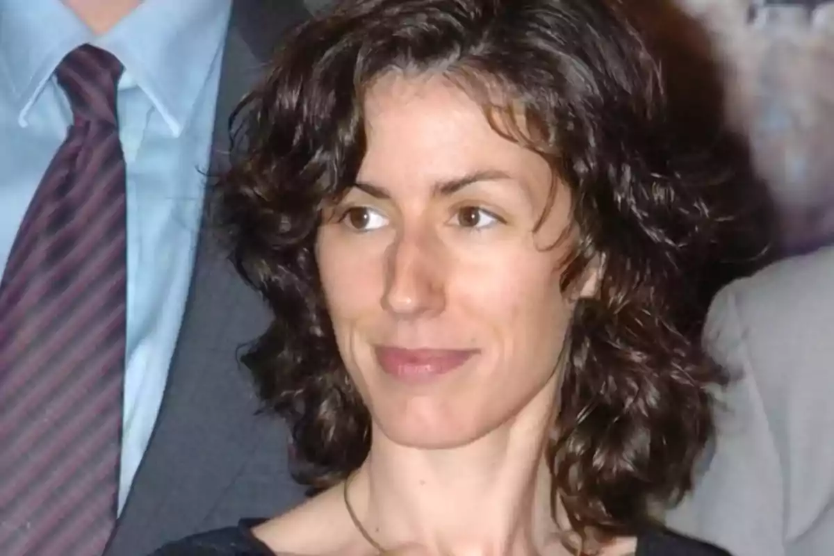 Una persona con cabello rizado y expresión serena en un entorno formal. Una persona con cabello rizado y expresión serena en un entorno formal.