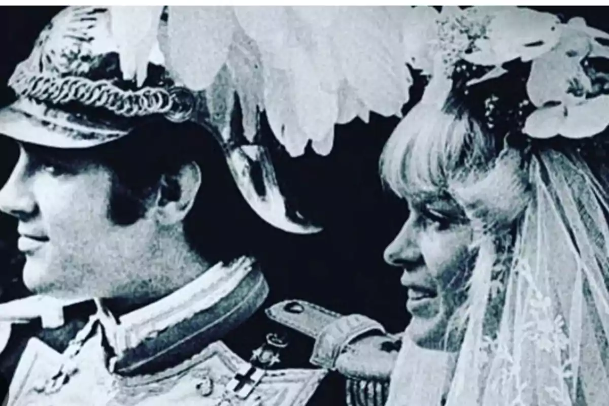 Una pareja vestida con trajes de época, el hombre lleva un casco metálico y la mujer un velo con flores. Una pareja vestida con trajes de época, el hombre lleva un casco metálico y la mujer un velo con flores.