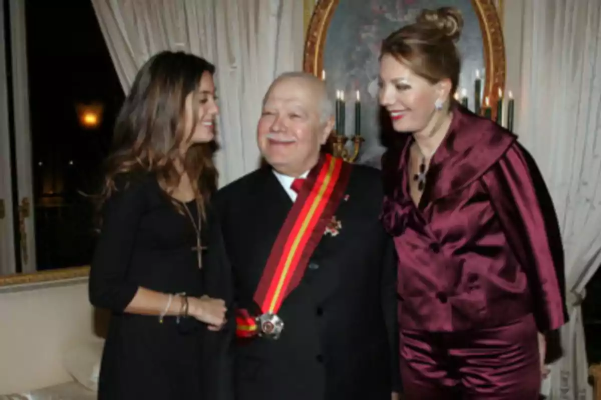 Tres personas elegantemente vestidas sonríen y conversan en un ambiente formal con cortinas y candelabros al fondo Tres personas elegantemente vestidas sonríen y conversan en un ambiente formal con cortinas y candelabros al fondo