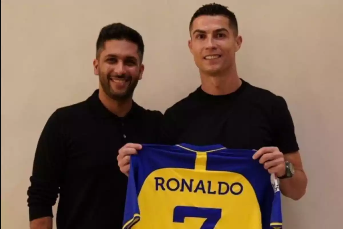 Dos personas sonríen mientras una de ellas sostiene una camiseta de fútbol azul y amarilla con el nombre Ronaldo y el número 7