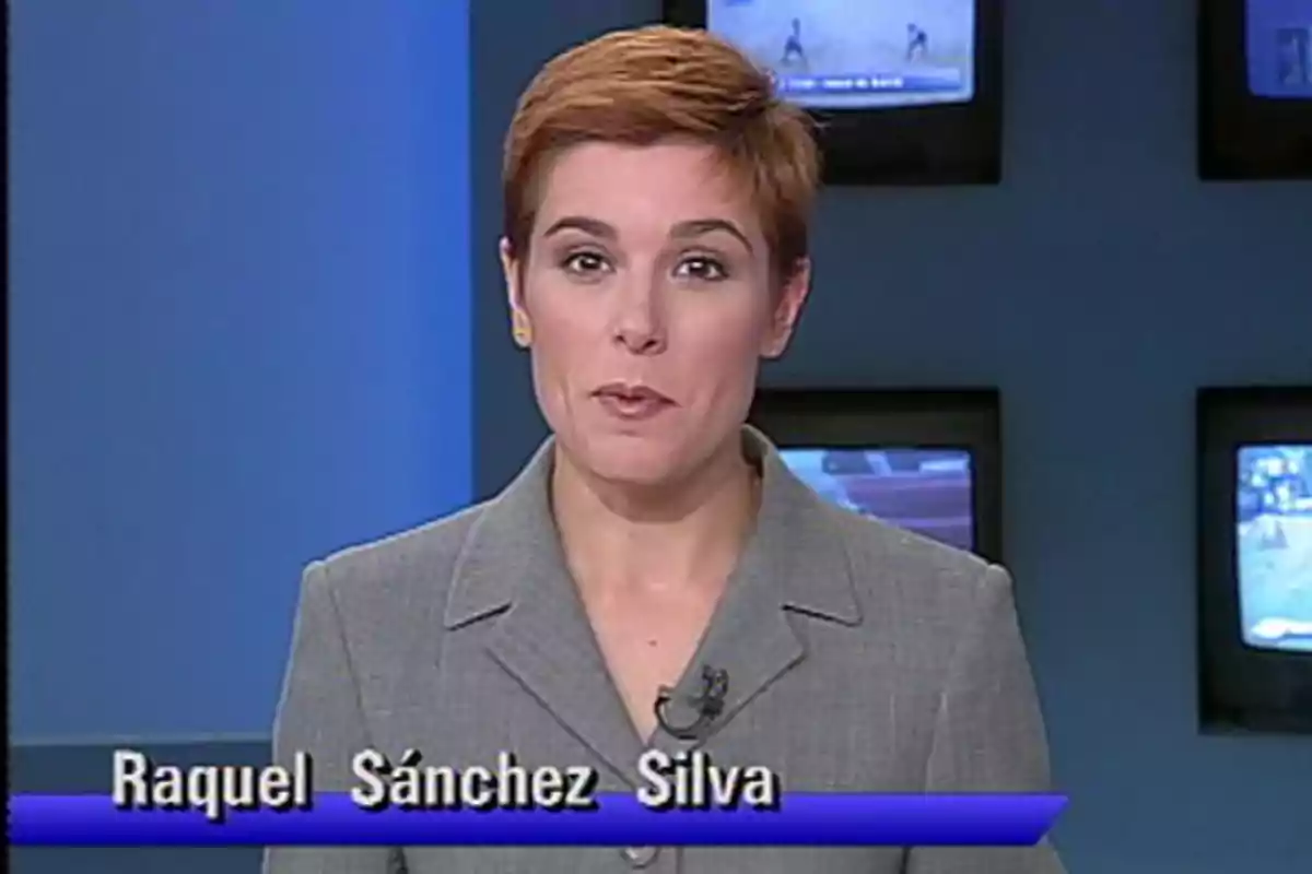 Presentadora de noticias con cabello corto y rojizo usando saco gris frente a varias pantallas de televisión en un estudio Presentadora de noticias con cabello corto y rojizo usando saco gris frente a varias pantallas de televisión en un estudio