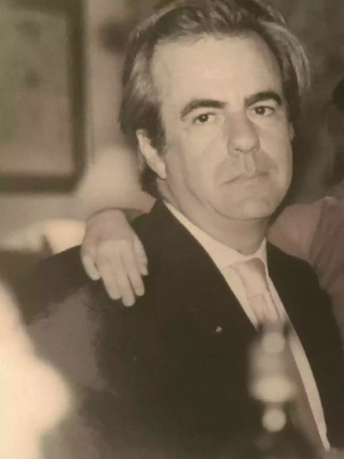 Hombre de mediana edad con expresión seria usando traje y corbata en una fotografía en blanco y negro Hombre de mediana edad con expresión seria usando traje y corbata en una fotografía en blanco y negro