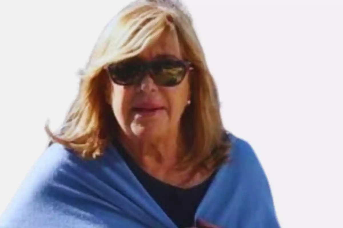 Mujer de cabello rubio con gafas de sol y un chal azul Mujer de cabello rubio con gafas de sol y un chal azul
