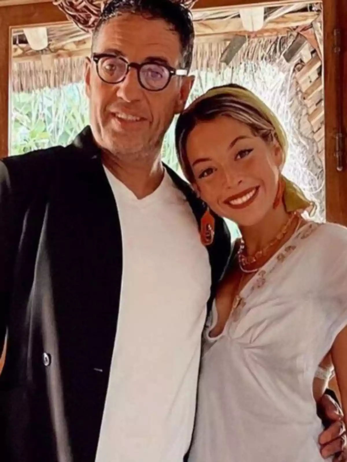 Un hombre con gafas y una mujer sonriente posan juntos en un ambiente interior de madera con luz natural. Un hombre con gafas y una mujer sonriente posan juntos en un ambiente interior de madera con luz natural.