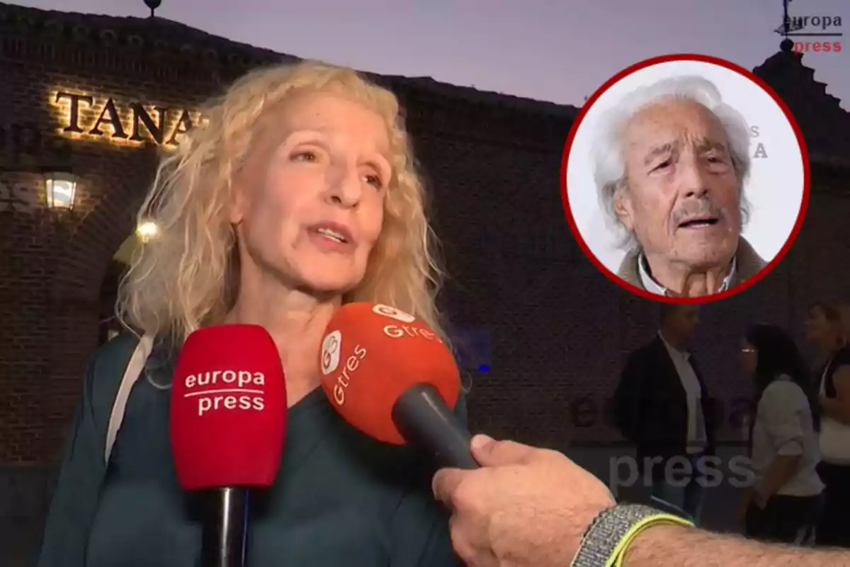 Mujer rubia hablando frente a micrófonos de prensa con fondo de edificio de ladrillo y un recuadro con la imagen de un hombre mayor en la esquina superior derecha