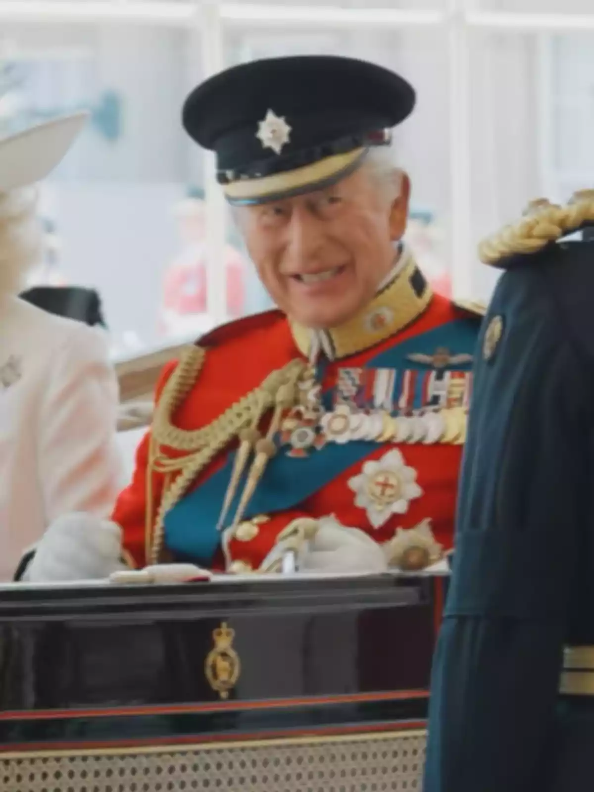 Older man in a red military uniform and black cap smiles while sitting in an elegant carriage Older man in a red military uniform and black cap smiles while sitting in an elegant carriage