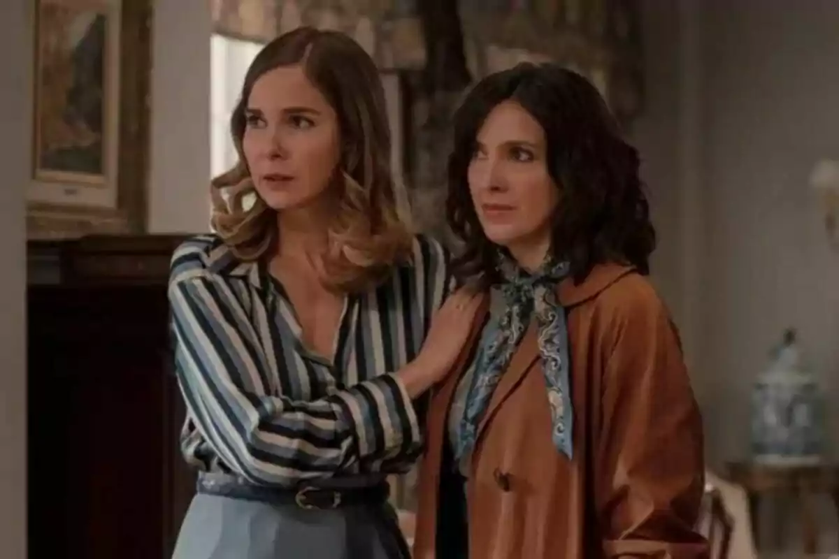 Natalia Sánchez y Carolina Lapausa de pie en una habitación, una con camisa de rayas y la otra con chaqueta marrón en una escena de 'Sueños de Libertad'. Natalia Sánchez y Carolina Lapausa de pie en una habitación, una con camisa de rayas y la otra con chaqueta marrón en una escena de 'Sueños de Libertad'.