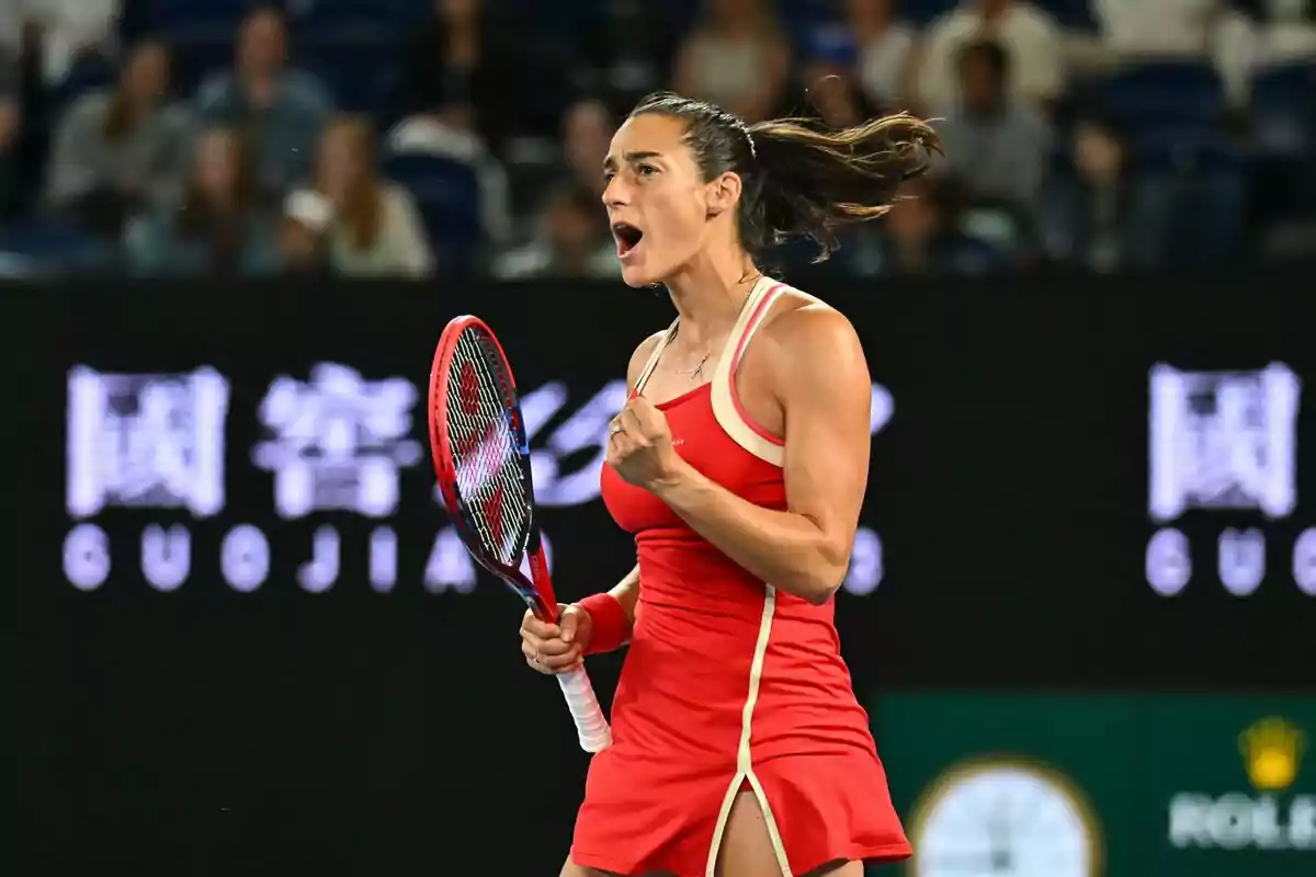 Jugadora de tenis celebrando un punto con el puño cerrado y una expresión de determinación en la cancha. Jugadora de tenis celebrando un punto con el puño cerrado y una expresión de determinación en la cancha.