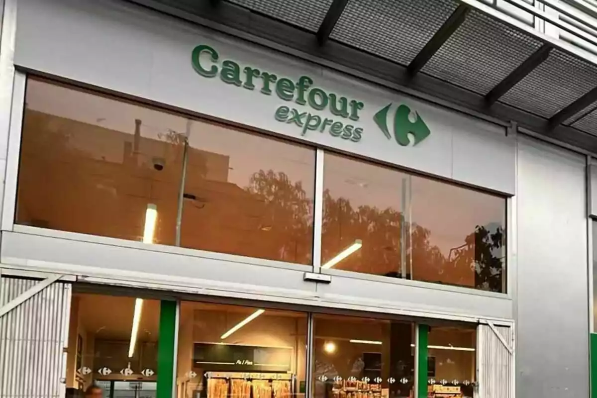 Fachada de una tienda Carrefour Express con puertas de cristal y letrero verde Fachada de una tienda Carrefour Express con puertas de cristal y letrero verde