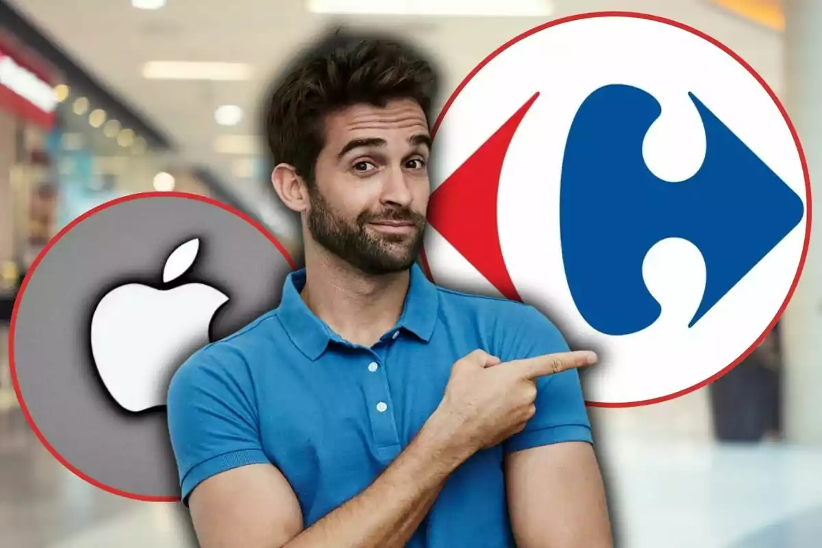 Un hombre con barba y camisa azul señala hacia dos logotipos grandes de Apple y Carrefour en un entorno de centro comercial.