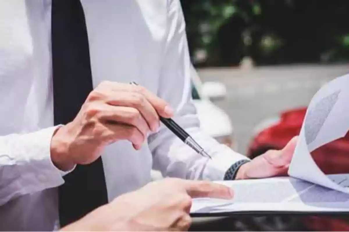 Dos personas revisando documentos al aire libre.