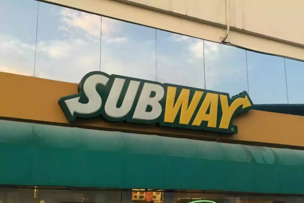 Un letrero de Subway, un restaurante de comida rápida, con fondo de cielo y nubes. Un letrero de Subway, un restaurante de comida rápida, con fondo de cielo y nubes.
