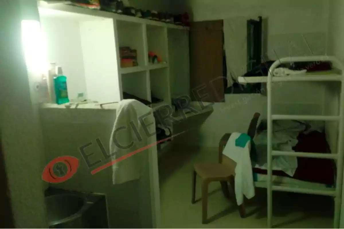 Una habitación con literas, estantes con objetos personales, una silla y un lavabo con artículos de higiene.