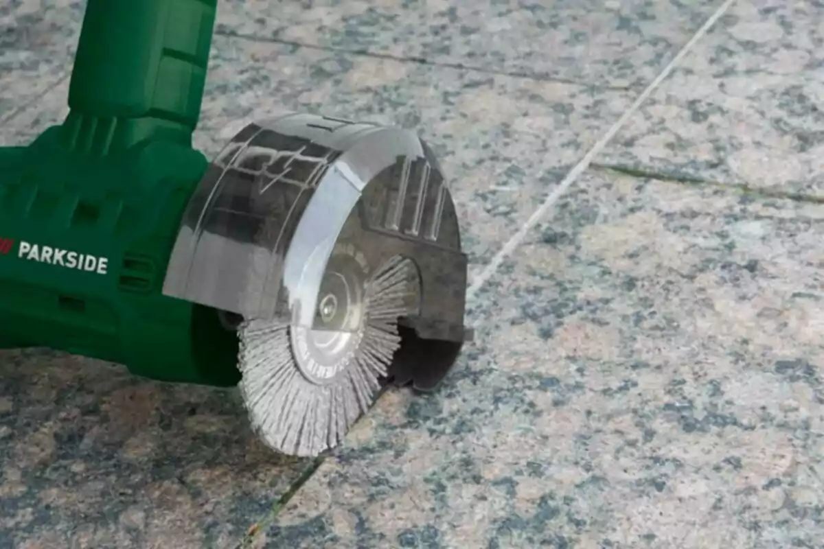 Una herramienta eléctrica con disco de corte está siendo utilizada sobre una superficie de baldosas. Una herramienta eléctrica con disco de corte está siendo utilizada sobre una superficie de baldosas.