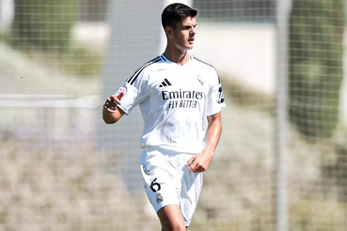 Futbolista con uniforme blanco del Real Madrid en el campo durante un partido Futbolista con uniforme blanco del Real Madrid en el campo durante un partido
