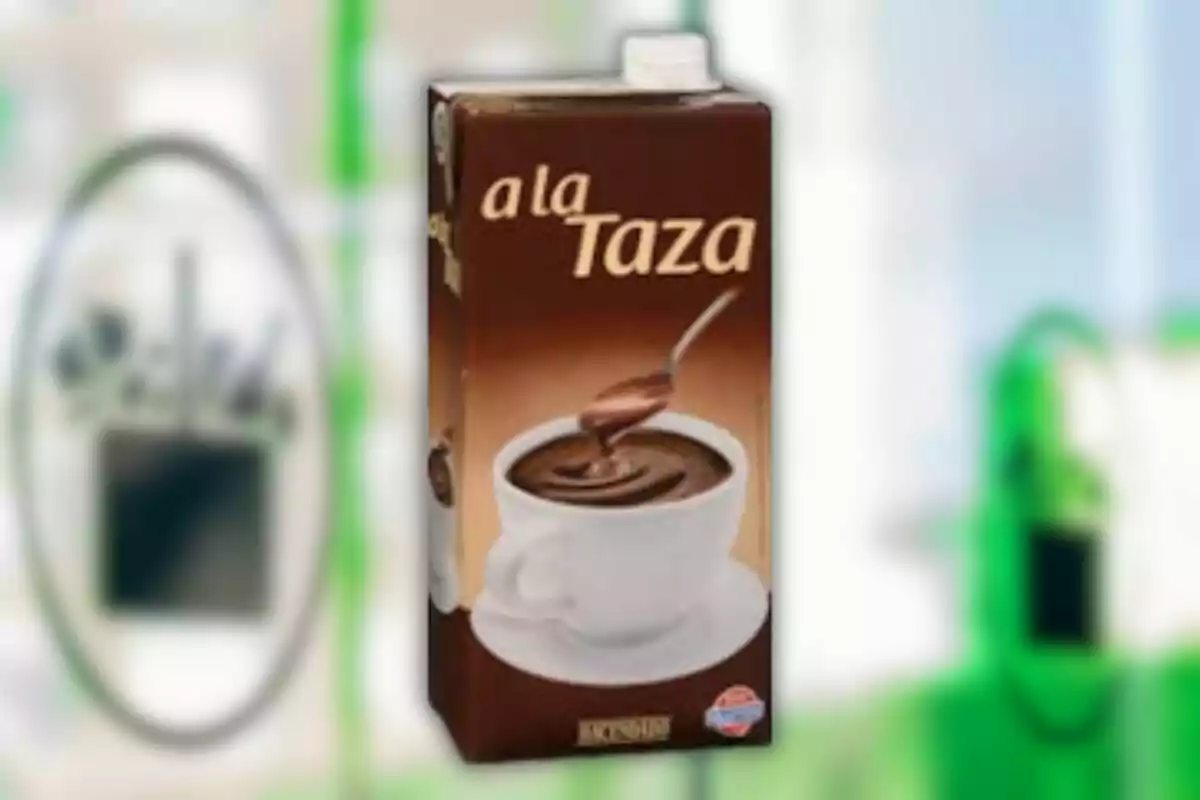 Envase de chocolate a la taza con una taza blanca llena de chocolate caliente y una cuchara Envase de chocolate a la taza con una taza blanca llena de chocolate caliente y una cuchara