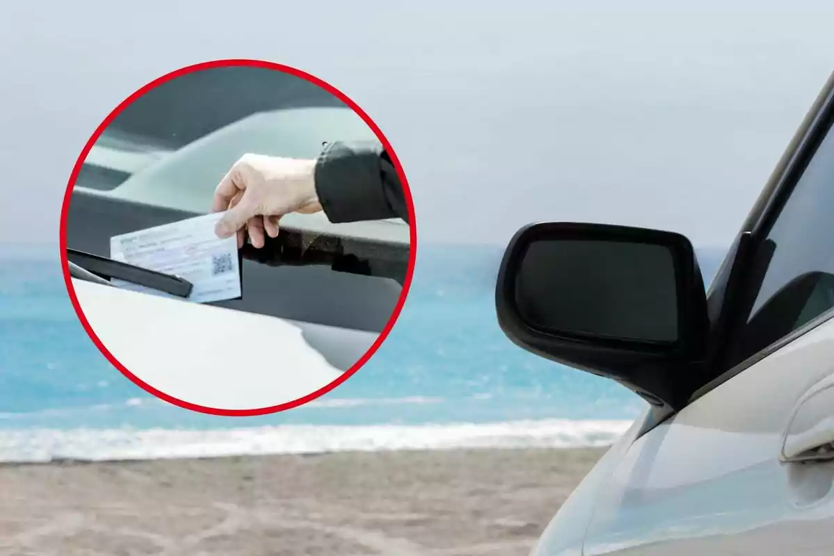 Una mano colocando un boleto en el parabrisas de un automóvil estacionado cerca de la playa.