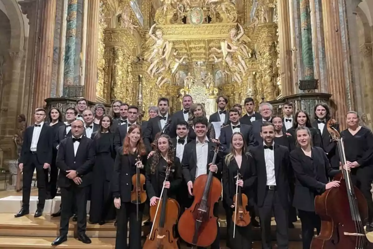 Un grupo de músicos posando con sus instrumentos en un escenario ornamentado con detalles dorados.