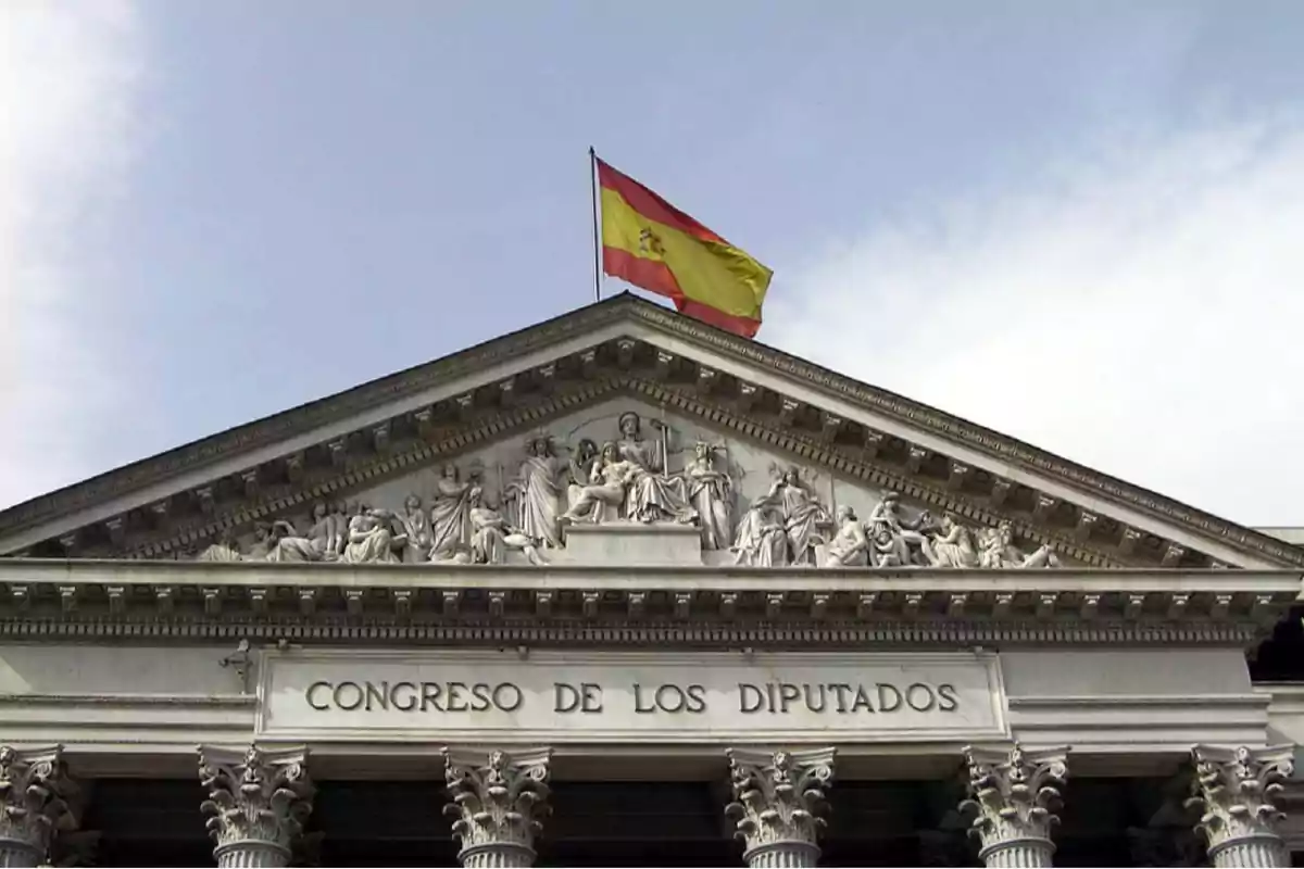 Fachada del Congreso de los Diputados en Madrid con la bandera de España ondeando en la parte superior.