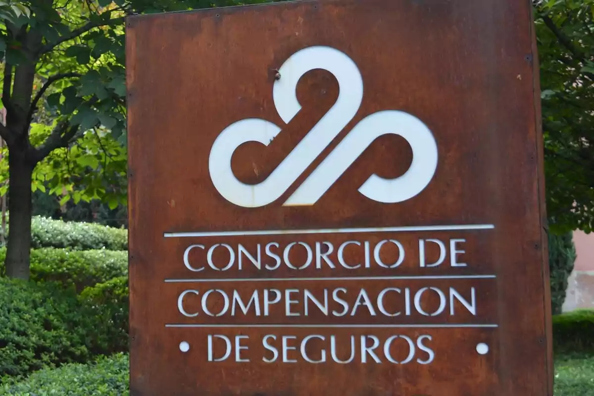 Letrero del Consorcio de Compensación de Seguros en un entorno con vegetación.