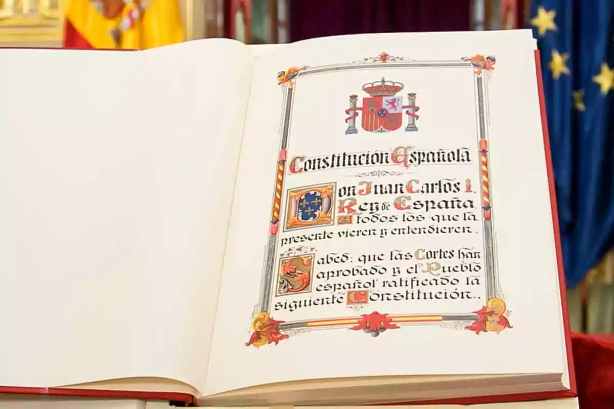 Una página abierta de un libro con un diseño decorativo que incluye el escudo de España y texto en estilo manuscrito.