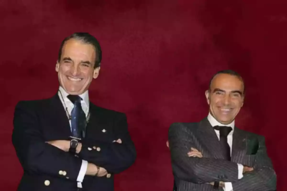 Dos hombres sonrientes con trajes formales posan con los brazos cruzados frente a un fondo rojo. Dos hombres sonrientes con trajes formales posan con los brazos cruzados frente a un fondo rojo.