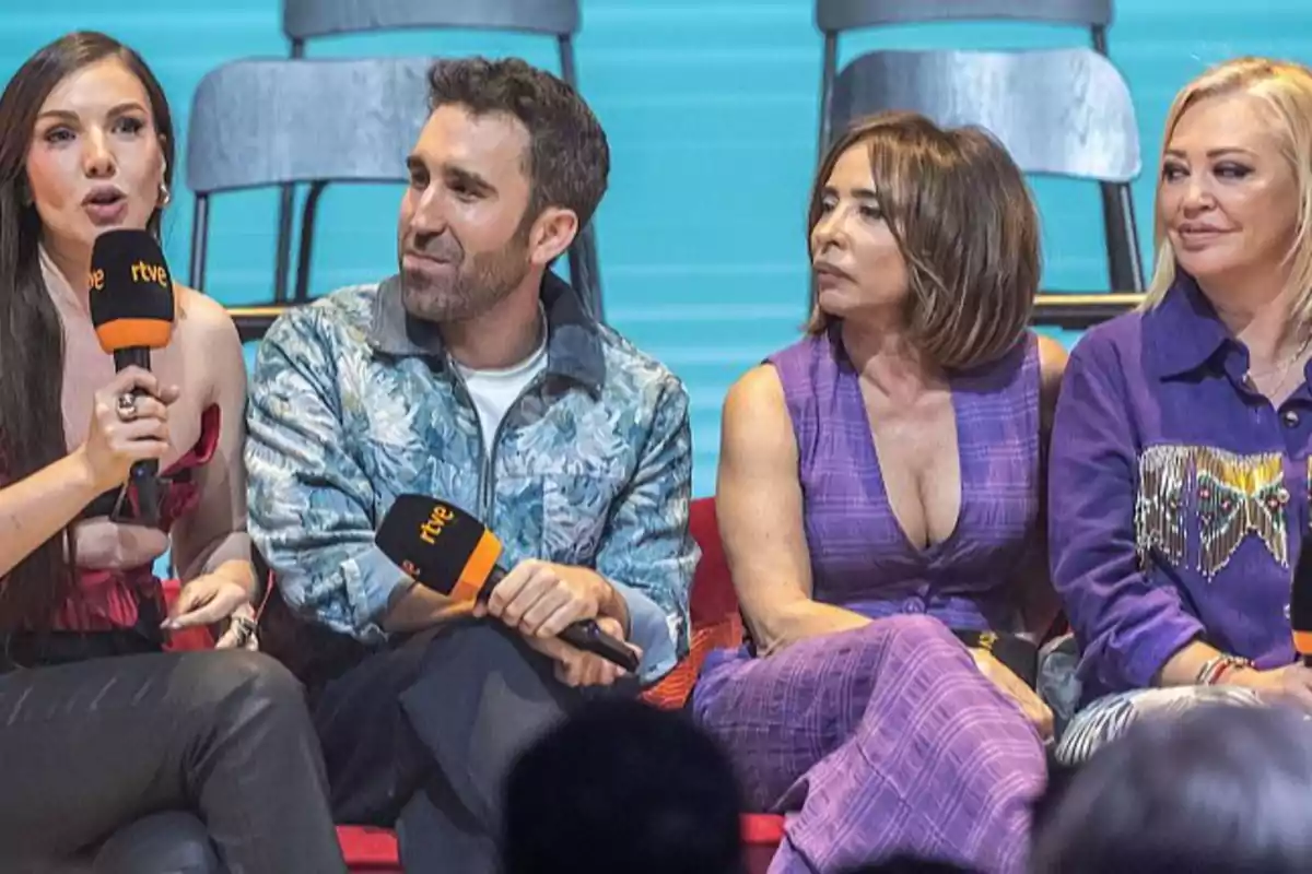 Cuatro personas sentadas en un escenario, dos de ellas sosteniendo micrófonos con el logo de RTVE.