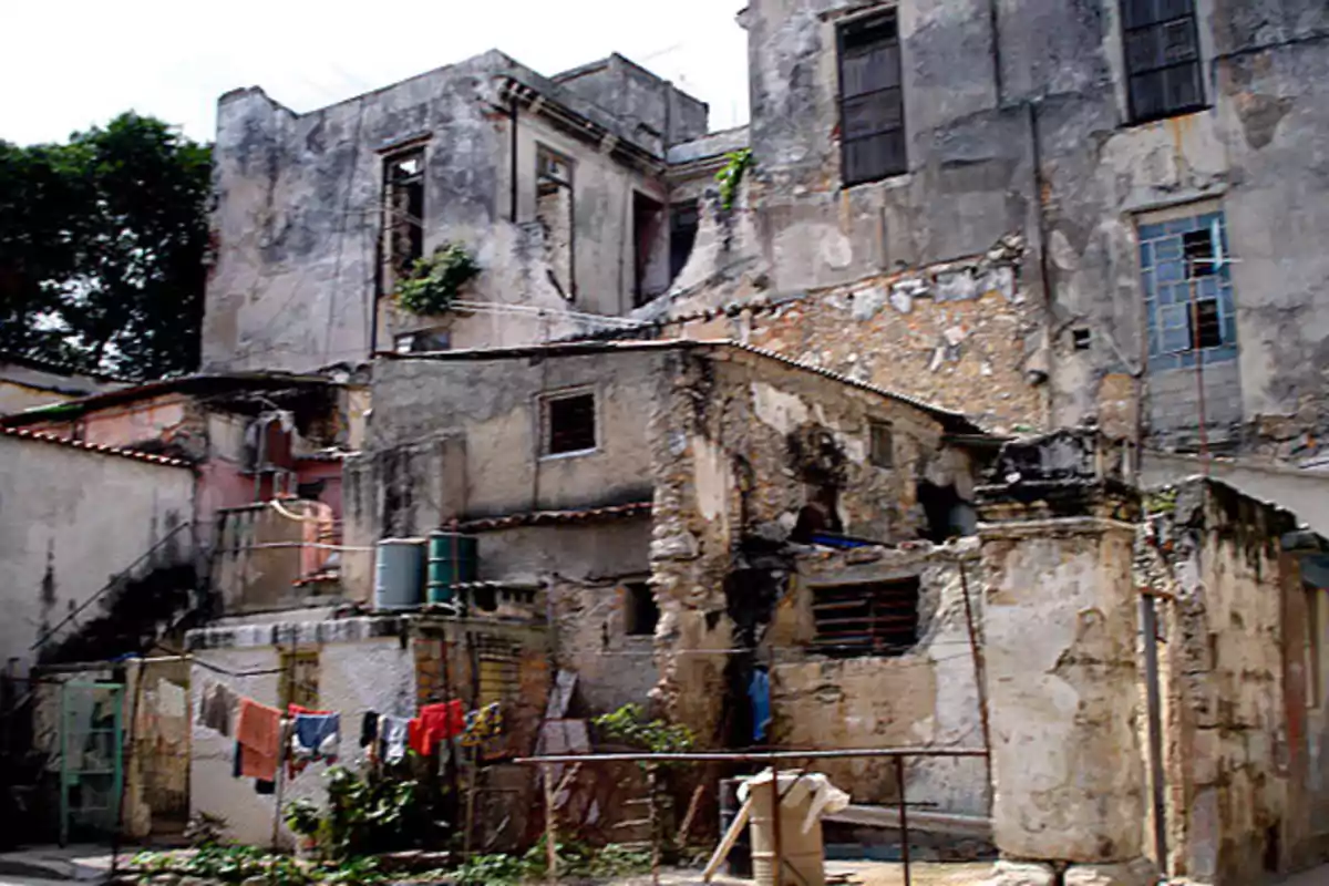 Edificio antiguo y deteriorado con ropa colgada en un tendedero en el patio.