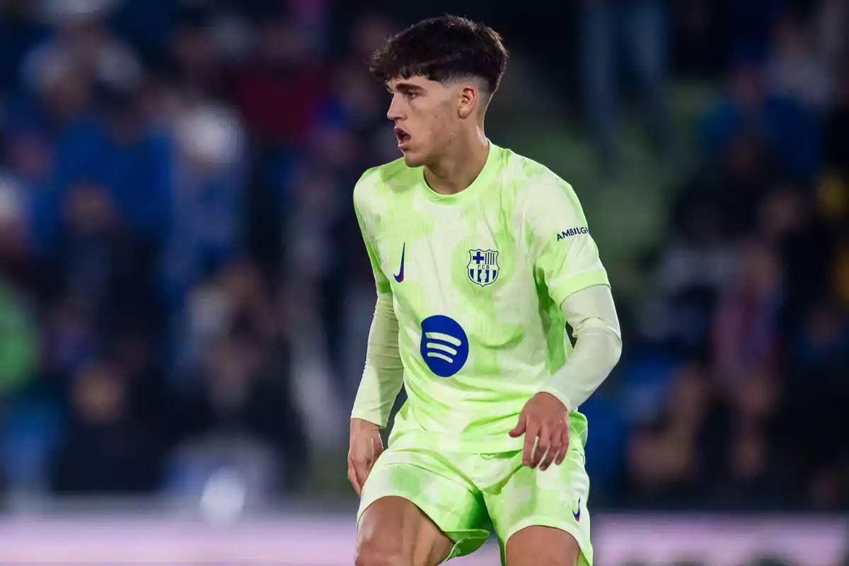 Jugador de fútbol con uniforme verde fosforescente del FC Barcelona en medio de un partido Jugador de fútbol con uniforme verde fosforescente del FC Barcelona en medio de un partido
