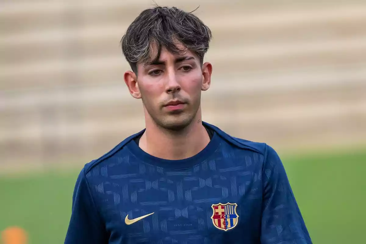 Joven con camiseta azul del FC Barcelona en un campo de entrenamiento Joven con camiseta azul del FC Barcelona en un campo de entrenamiento