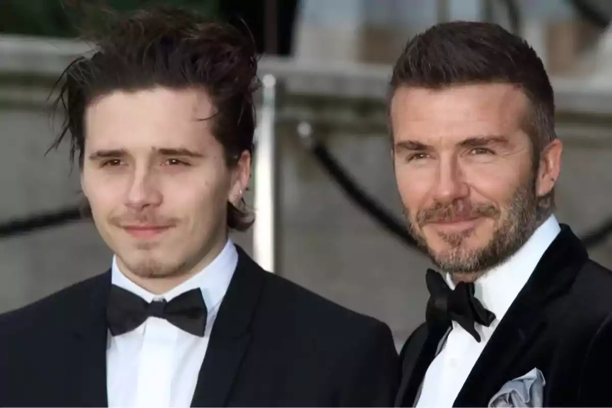 Dos hombres vestidos de traje y corbata de moño posan juntos al aire libre. Dos hombres vestidos de traje y corbata de moño posan juntos al aire libre.