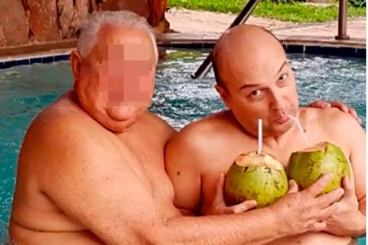 Dos personas en una piscina sosteniendo cocos con popotes.