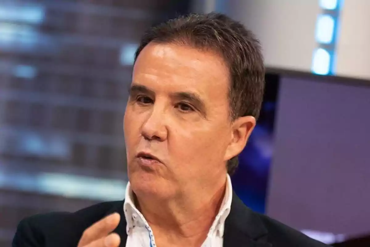 Un hombre hablando en un entorno de estudio de televisión.
