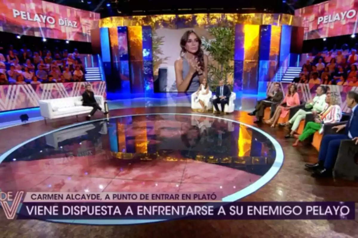 Un plató de televisión con público y varios presentadores sentados en sofás mientras una gran pantalla muestra la imagen de una mujer. Captura de '¡De Viernes!' Un plató de televisión con público y varios presentadores sentados en sofás mientras una gran pantalla muestra la imagen de una mujer. Captura de '¡De Viernes!'