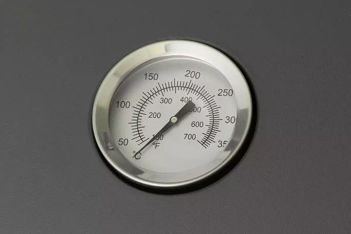 Termómetro redondo con escala en grados Celsius y Fahrenheit sobre fondo gris. Termómetro redondo con escala en grados Celsius y Fahrenheit sobre fondo gris.