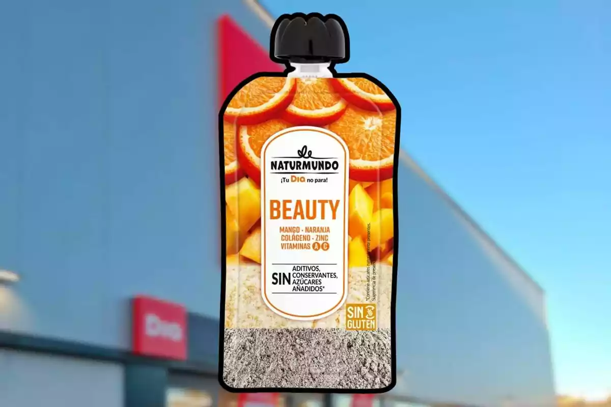 Envase de suplemento alimenticio Naturmundo Beauty sabor mango y naranja con colágeno, zinc y vitaminas, frente a una tienda con letrero rojo. Envase de suplemento alimenticio Naturmundo Beauty sabor mango y naranja con colágeno, zinc y vitaminas, frente a una tienda con letrero rojo.
