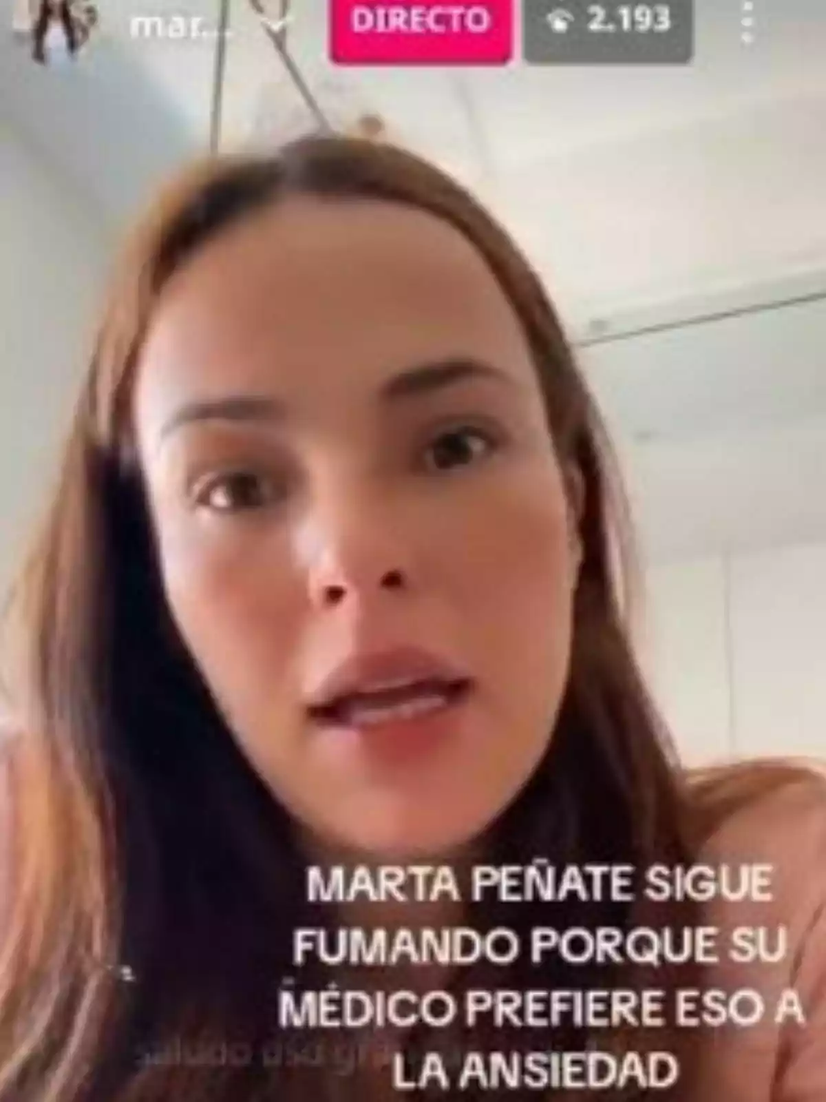 Marta Peñate hablando frente a la cámara durante una transmisión en vivo con un texto en pantalla que menciona que sigue fumando por recomendación médica para controlar la ansiedad Marta Peñate hablando frente a la cámara durante una transmisión en vivo con un texto en pantalla que menciona que sigue fumando por recomendación médica para controlar la ansiedad