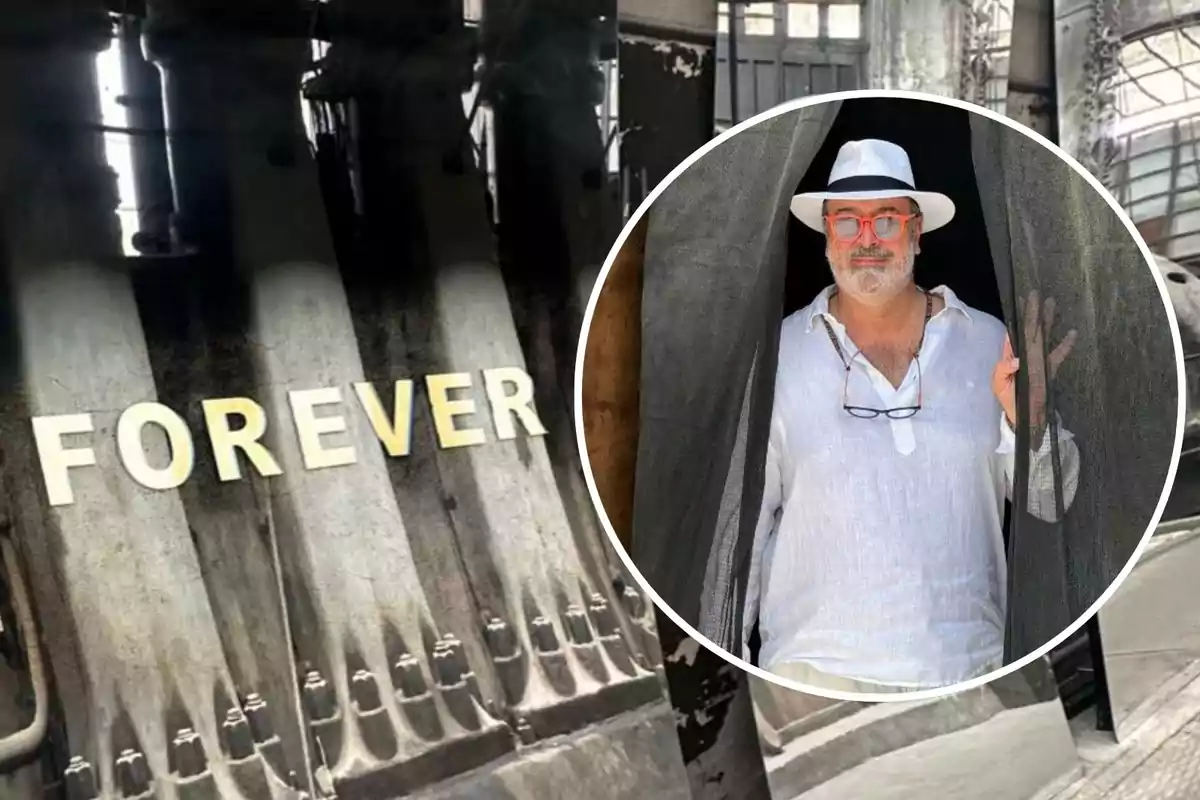 Un hombre con sombrero y gafas rojas está de pie en una puerta, mientras que en el fondo se ve la palabra "FOREVER" en una estructura industrial.