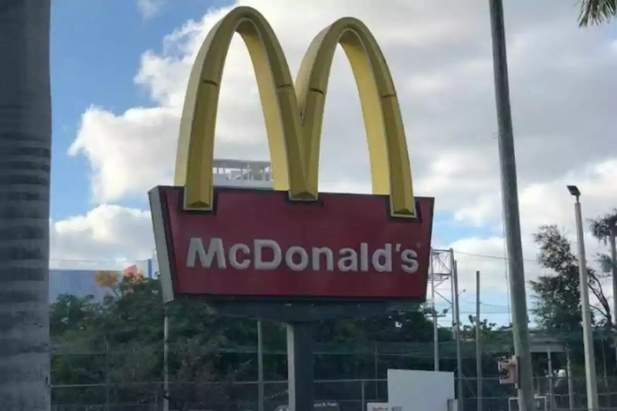 Letrero de McDonald's con el icónico logo de los arcos dorados sobre un fondo de cielo nublado Letrero de McDonald's con el icónico logo de los arcos dorados sobre un fondo de cielo nublado