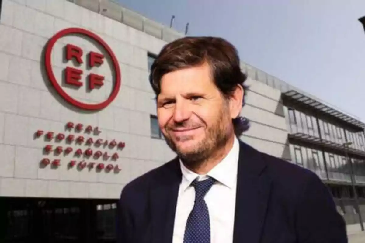 Un hombre con traje y corbata frente a un edificio con el logo de la Real Federación Española de Fútbol.
