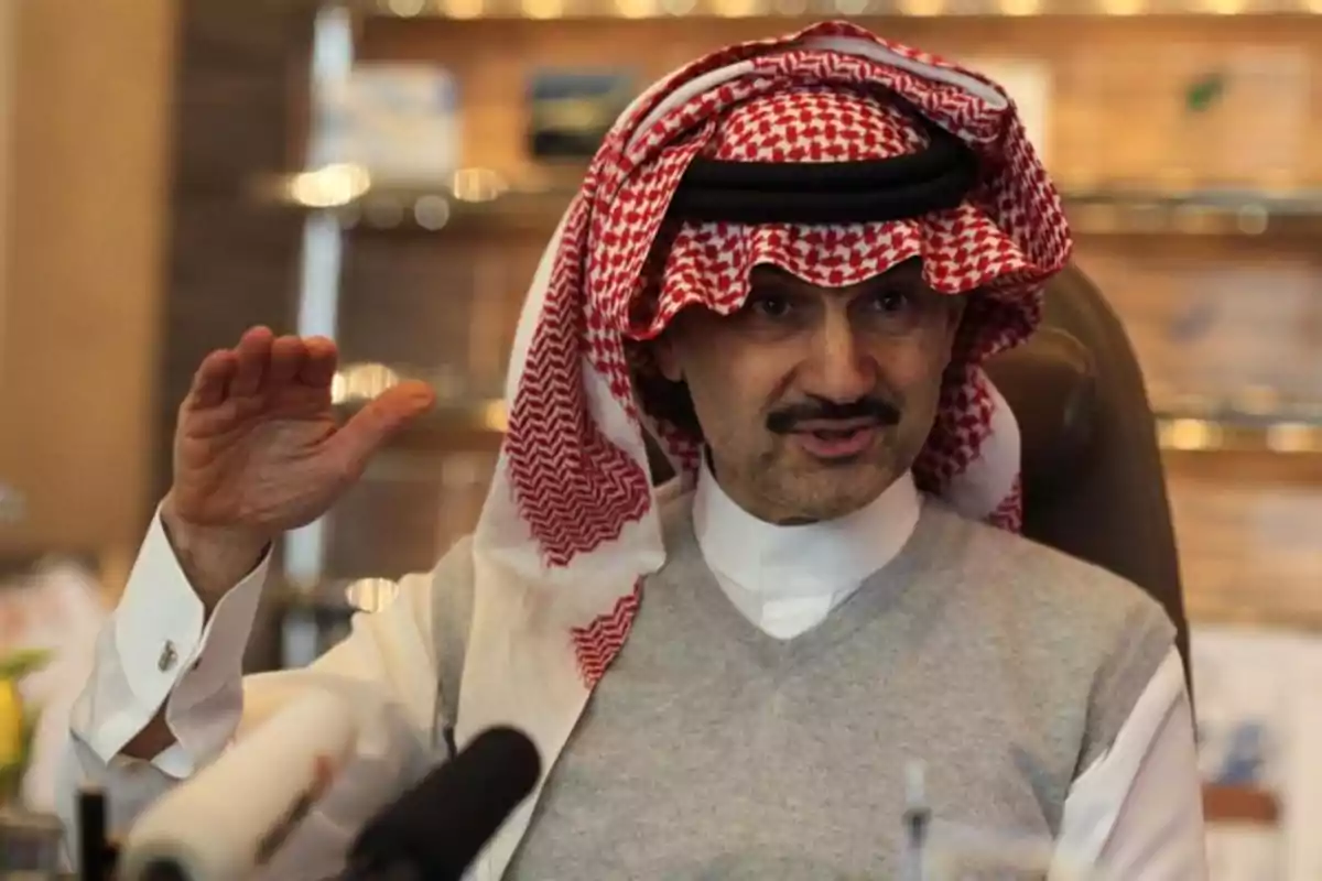 Man in traditional Arab clothing sitting in an office gesturing with his right hand raised Man in traditional Arab clothing sitting in an office gesturing with his right hand raised
