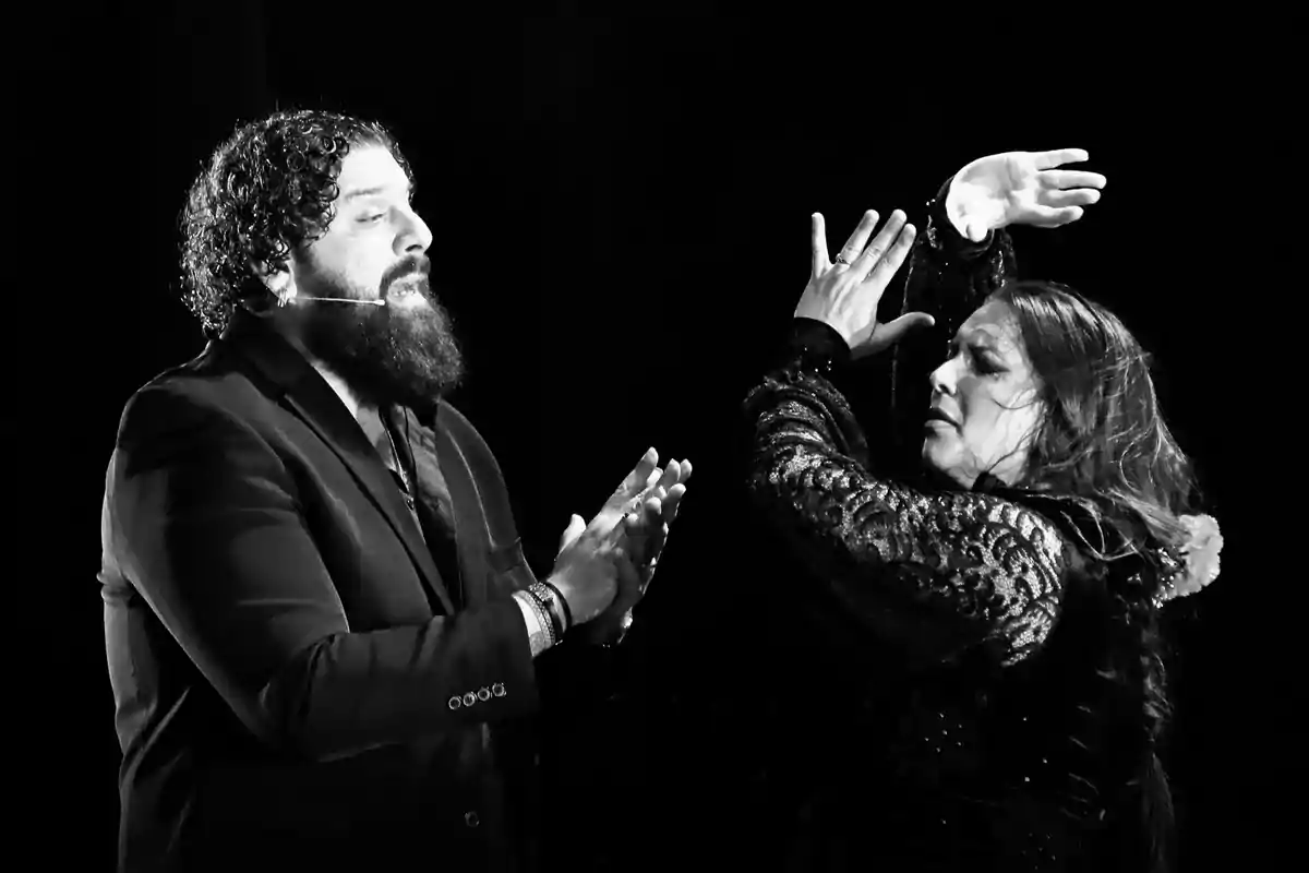 Un hombre y una mujer en una actuación de flamenco en blanco y negro.
