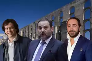 Tres hombres posando frente a un acueducto antiguo bajo un cielo despejado.